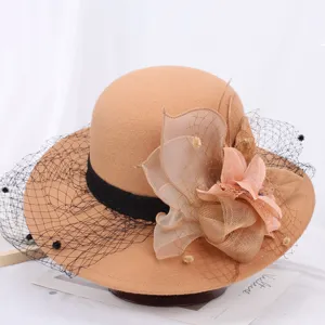 Detail view of elegant camel women woolen bucket hat with black ribbon mesh and floral decor.
