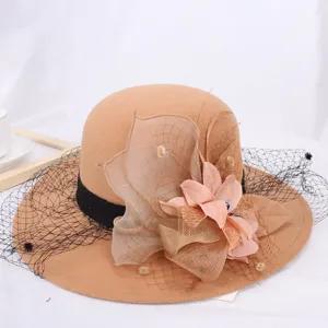 Close-up of the elegant wool bucket hat featuring delicate fabric flowers and black mesh veiling.