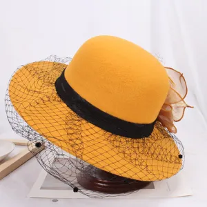 Elegant yellow wool felt bucket hat with black lace mesh veil and floral side accent.