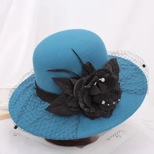 Detail view of elegant blue wool cloche hat featuring black floral applique, mesh veil, feathers.