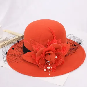 Detail view of red woolen bucket hat featuring black mesh, floral applique, and pearl tassels.