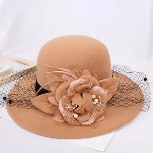 Detailed view of the elegant camel felt bucket hat featuring floral, feather and mesh decor.