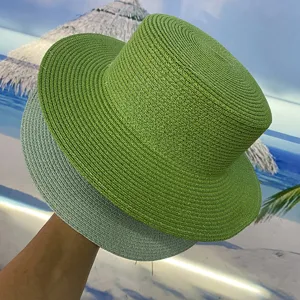 Vue de détail chapeau de paille plat femme été, visière de plage vert et gris.