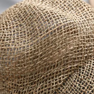 Primer plano de la textura del sombrero de paja con diseño de malla calada transpirable.