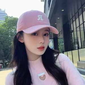 Vue détaillée de la casquette de baseball en coton rose avec broderie de lettre R blanche.