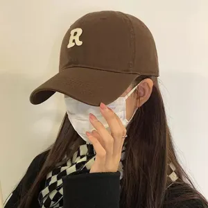 Vue détaillée de la casquette de baseball en coton marron avec logo R blanc.