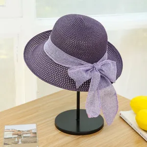 Close-up of the purple straw sun hat featuring a delicate bowknot detail and woven texture.