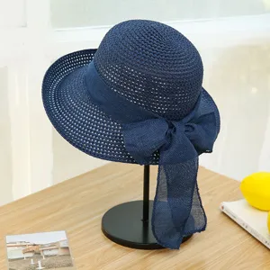 Detail shot of a stylish navy blue hollow-out woven sun hat with long bow ribbon.