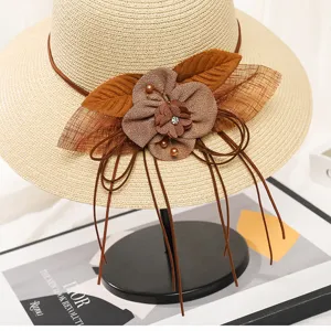 Detailansicht des Sommer-Strohhutes fuer Damen mit Stoffblumen-Dekor und langen Baendern.