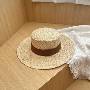 Gedetailleerd overzicht van dames zomer platte strohoed met bruin lint, stijlvolle zonbescherming.