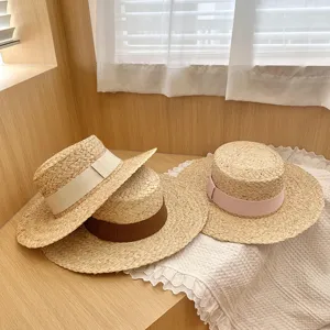 Raffia platte hoed detail, natuurlijk geweven textuur met lint, zomerse strandbescherming.