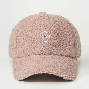 Cute pink sherpa baseball cap detail featuring embroidered rose and love text for casual style.
