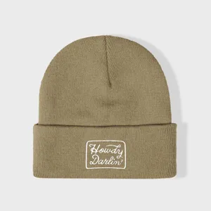 Khaki gebreide muts met witte geborduurde patch, gedetailleerd overzicht van de warme muts.