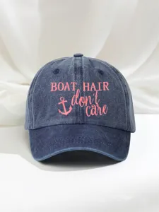 Detailed view of the washed blue denim baseball cap featuring pink anchor embroidery.