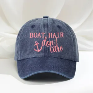 Classic dark blue washed denim baseball cap featuring pink embroidered boat hair design for outdoor.