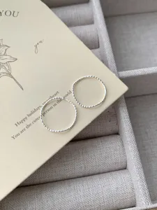 Gros plan détaillé de bagues vagues en argent sterling au travail texturé très délicat.
