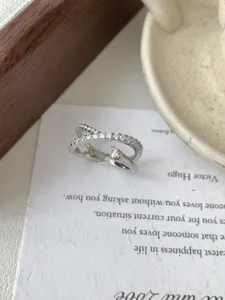 Détail de bague croisée météore en argent sterling S925, oxydes de zirconium scintillants.