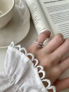 Gros plan détaillé d'une bague météore croisée en argent sterling S925 avec oxydes de zirconium.