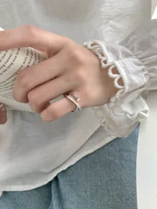 Vue détaillée de la bague croisée météore en argent sterling S925 avec strass brillants.