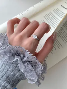 Gros plan détail d'une bague en argent sterling avec diamant en forme de poire sur la main.