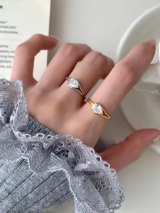 Gros plan détaillé de bagues en argent et or avec zircone cubique taille poire.