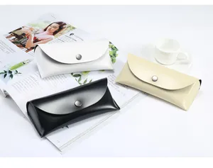 Vue détaillée d'étuis à lunettes de soleil en cuir portables en noir, blanc et beige.