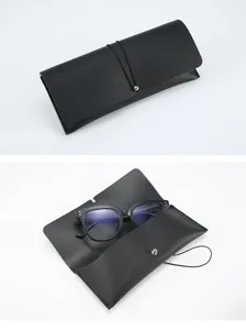 Detailed view of black leather glasses case with elastic string closure and framed eyeglasses.