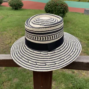 Detailed view of the vintage black and white woven straw boater hat with black ribbon.