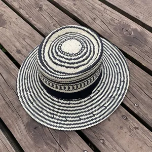 Detailed view of a black and white woven straw hat showing intricate pattern and texture.