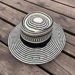 Stylish black and white woven straw hat for women, retro flat brim sun protection beach cap.
