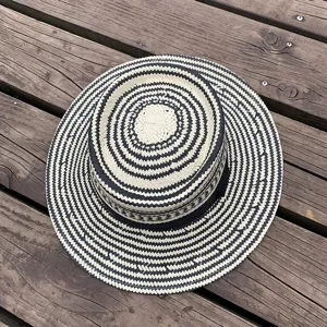 Detailed top view of a stylish black and white woven straw sun hat with a black ribbon.