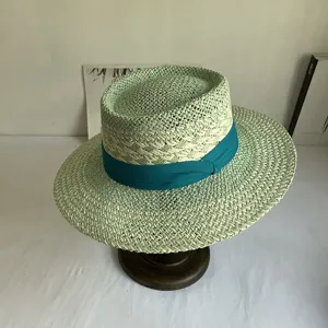 Mint green straw hat detail showcasing fine weaving and a chic dark teal ribbon decoration.