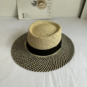 Detailed view of the vintage flat-top straw hat with black ribbon and woven brim design.