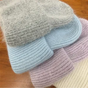 Gros plan détaillé de bonnet tricoté duveteux en mohair de plusieurs couleurs douces.