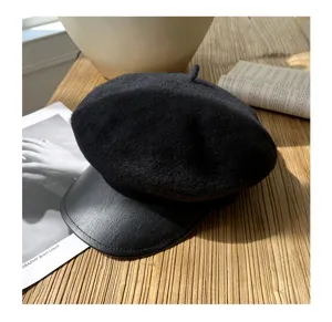 Nahaufnahme Detail der schwarzen Wollbarette mit Lederschirm, elegante herbstliche Mütze.
