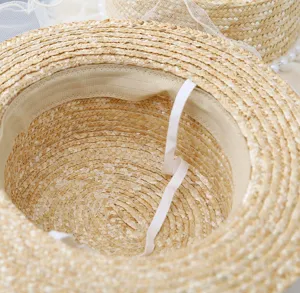 Kinderstrooien hoed binnendetail toont fijne weefselstructuur en witte elastische band.