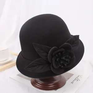 Detailweergave van de zwarte wollen viltklokhoed met elegante stoffen bloemversiering.