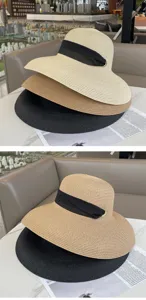 Vista dettagliata cappello di paglia donna tesa larga nastro nero anello metallo spiaggia.