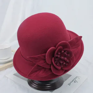 Dames wijnrode wolvilten klokhoed hoed met elegante bloemblad decoratie voor de koude herfst.
