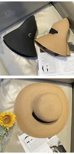 Vista dettagliata di elegante cappello di paglia da sole a tesa larga con nastro nero e anello.