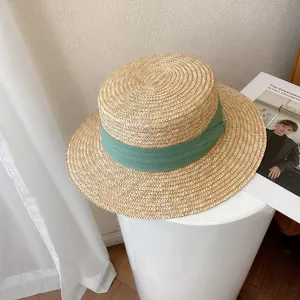Retro flat top straw hat featuring green ribbon, stylish summer beach sun protection hat.