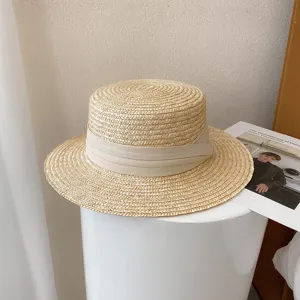 Retro flat top straw hat with beige ribbon detail, perfect stylish summer sun protection beach hat.