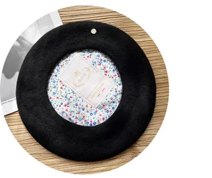Detalle de primer plano boina de lana negra con forro floral y decoracion metalica en madera