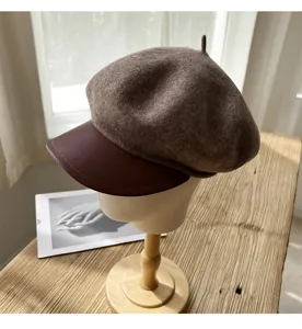 Braune Woll-Schiebermütze mit Lederkrempe, eleganter Retro-Damenhut für den Winter.