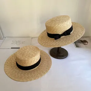 Schickes flaches Strohhut-Detail, mit eleganter schwarzer Schleife für den Sommerurlaub.