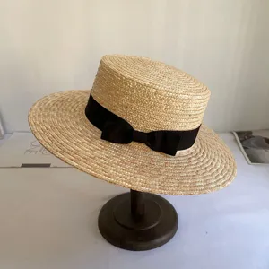 Nahaufnahme Detailansicht des eleganten handgeflochtenen Strohhuts mit schwarzer Schleife.