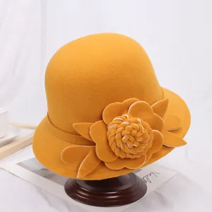 Detailopname van de gele wollen vilt hoed met elegante handgemaakte bloemendecoratie.