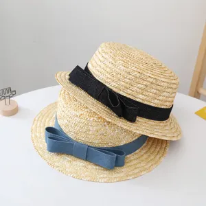Gedetailleerd overzicht van strohoed set met strikken, natuurlijke zomer strand stijl.