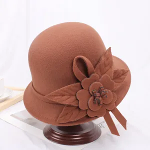 Gedetailleerde close-up van de elegante bruine viltkoepelhoed met bloembladdecoratie.