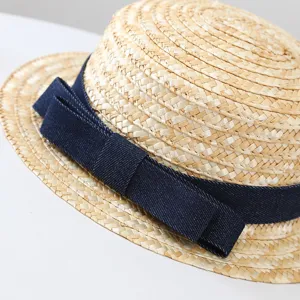 Detailopname van een zomerse strohoed met een stijlvolle donkerblauwe denimbrik en weefstructuur.